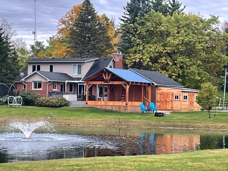 Rough-cut timber 3-season room built by ZoltanBuilds, overlooking a pond