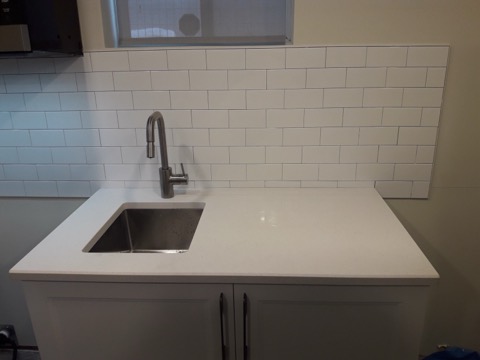 Undermount sink, quartz counter and subway-tile backsplash installed by ZoltanBuilds