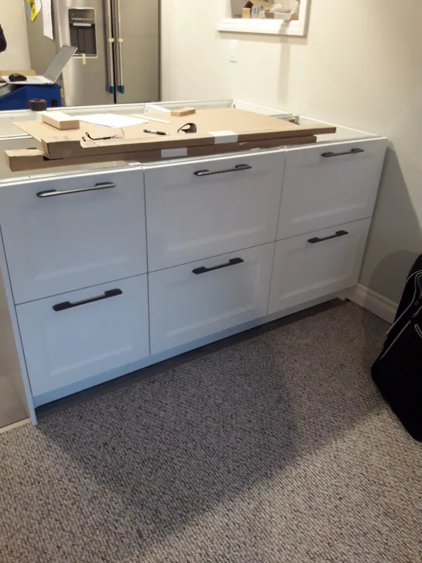White shaker drawer cabinets for the island being installed, before the countertop went on